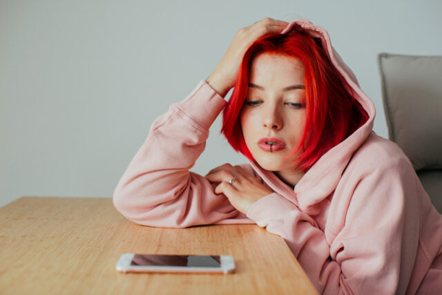 young woman staring at smartphone